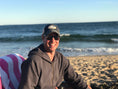 Load image into Gallery viewer, Lifestyle photo at the beach wearing a Beachmate adult trucker hat