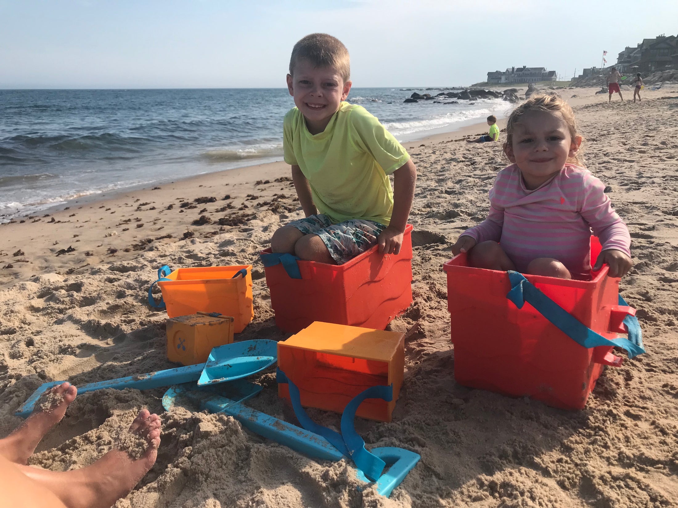 Beachmate orange bucket with blue shovel on the sand