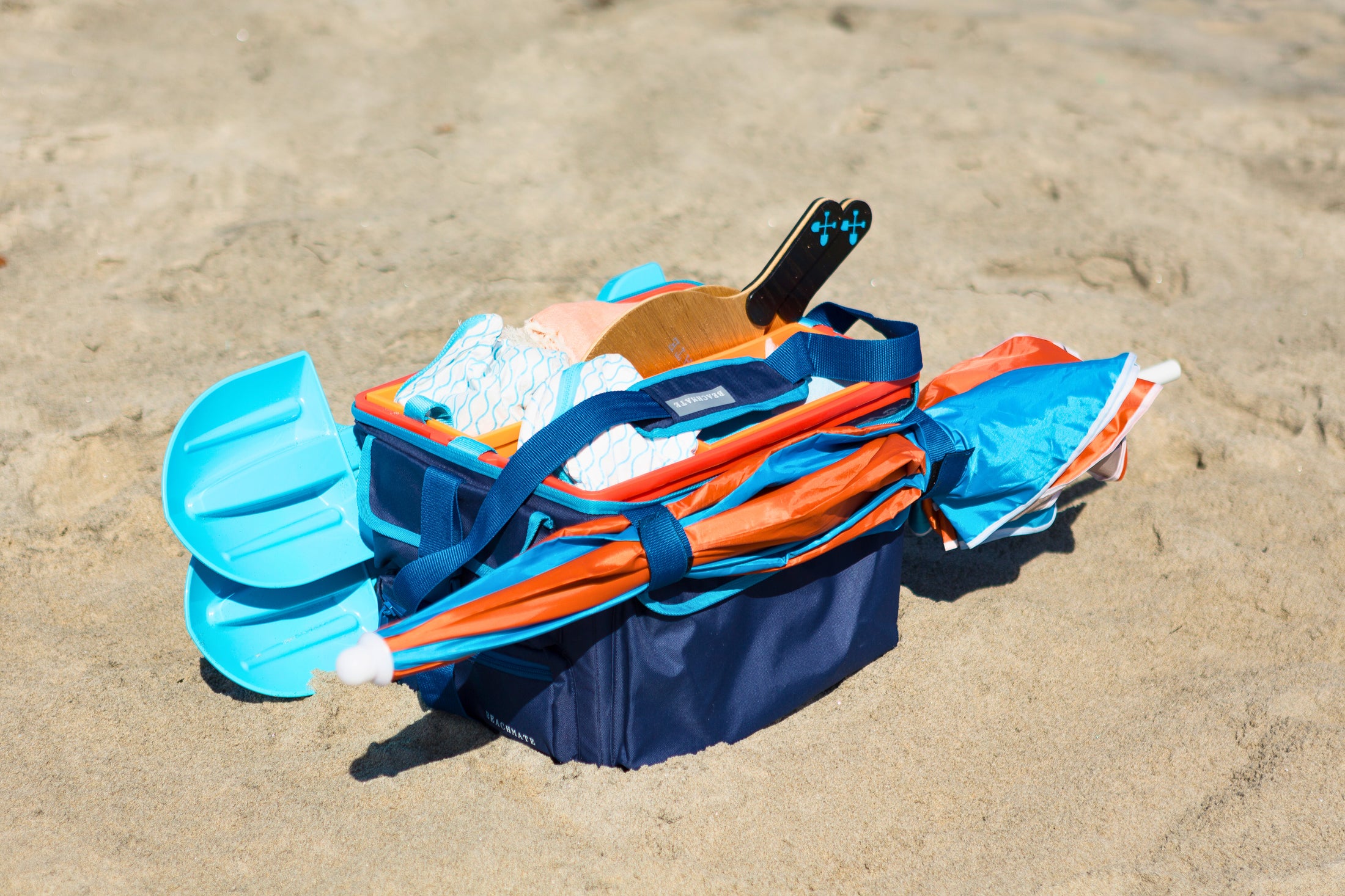 Medium Beachmate accessory pouch packed alongside Beachmate buckets and tote on the sand