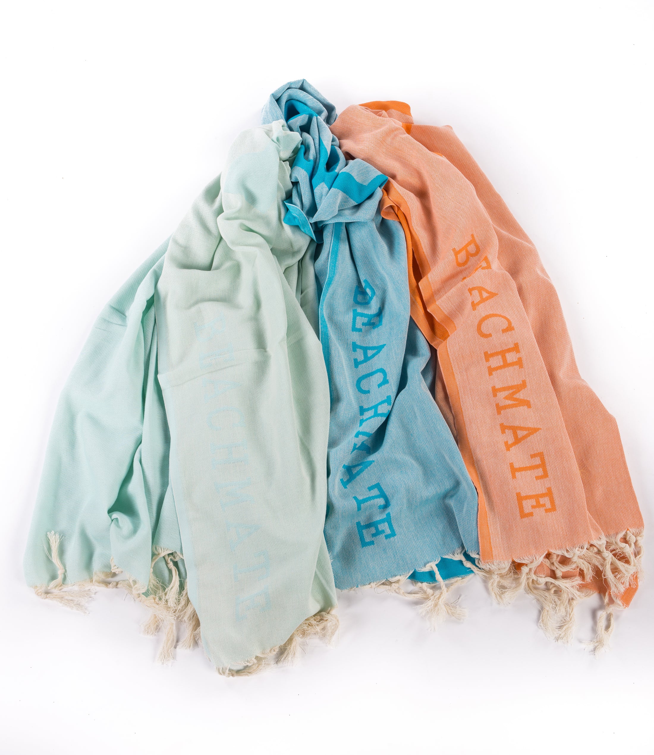 Three Turkish towels in mint green, blue, and orange colors with hand-tied fringe, laid out flat. Mint Turkish towel by Beachmate — lightweight, quick‑dry beach towel