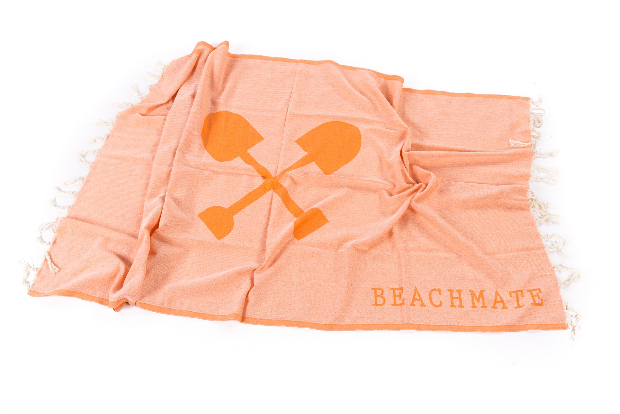 An orange Turkish towel with hand-tied fringe and the text 'BEACHMATE' displayed on it.