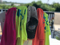 Load image into Gallery viewer, Beachmate towels and kids swim shirts at the shoreline, family beach setup

