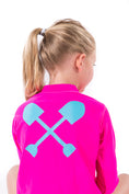 Load image into Gallery viewer, Child wearing pink Beachmate long‑sleeve UPF 50 rash guard, crossed‑shovels logo on back

