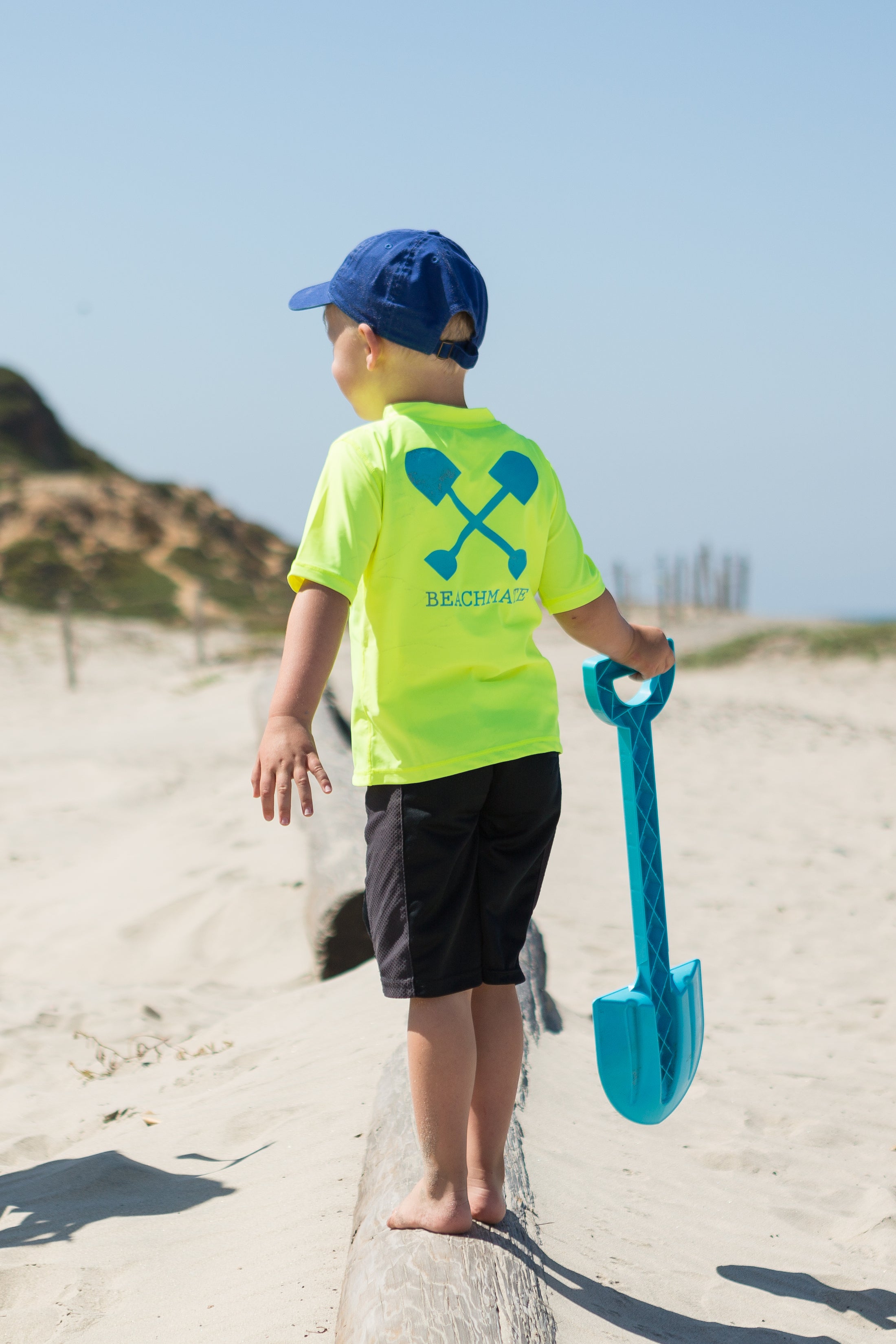 Child at the beach wearing Beachmate UPF 50 short‑sleeve swim shirt